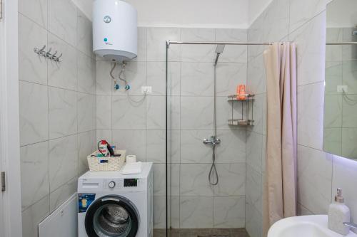 a bathroom with a washing machine and a shower at Luxury Apartment with Parking in Tirana