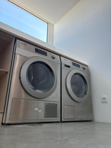 two washing machines sitting next to each other in a room at Angeiras Beach Hostel in Lavra