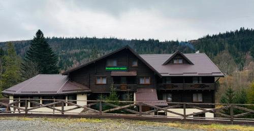 a log cabin building with a sign on it at Drozdovichi Resort in Oryavchyk