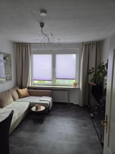 a living room with a couch and a window at Ferienwohnung in Fuldatal bei Kassel in Fuldatal