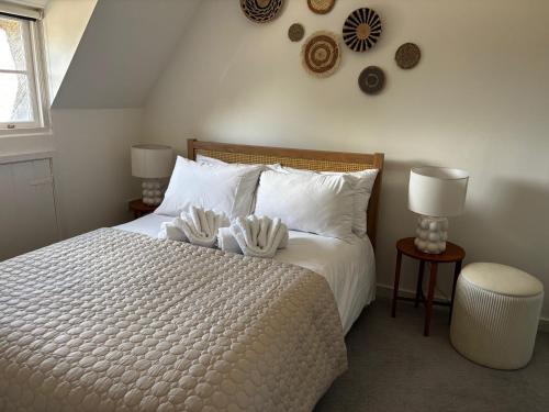 a bedroom with a white bed with two towels on it at Bracken Cottage in Weymouth