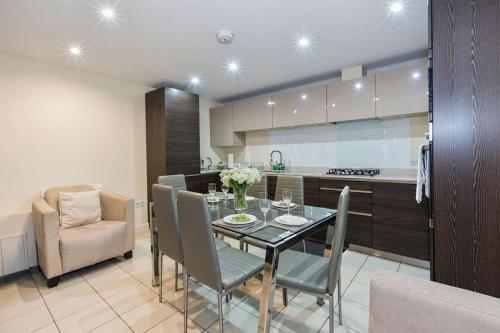 a kitchen and dining room with a table and chairs at Amanah Properties - Elegant Home in Shepherds Bush, steps from Westfield, Sleeps 8 in London