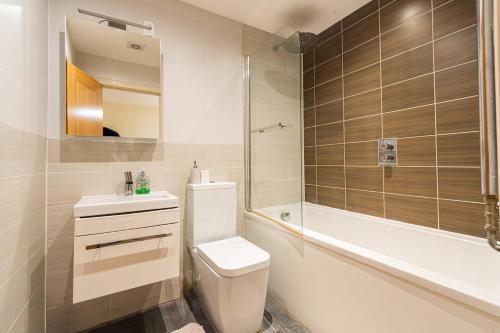 a bathroom with a toilet and a sink and a tub at Amanah Properties - Elegant Home in Shepherds Bush, steps from Westfield, Sleeps 8 in London