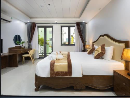 a bedroom with a large bed and a desk at Berlin Haus Nha Trang Hotel in Nha Trang