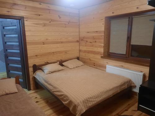 スヴィチャスにあるSopko restの木製の壁の部屋にあるベッドのある寝室