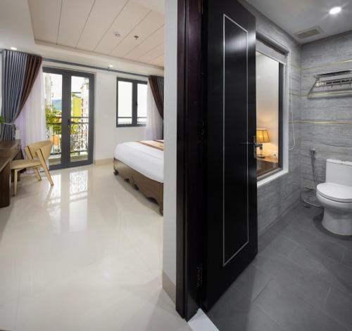 a bedroom with a bed and a bathroom with a toilet at Berlin Haus Nha Trang Hotel in Nha Trang