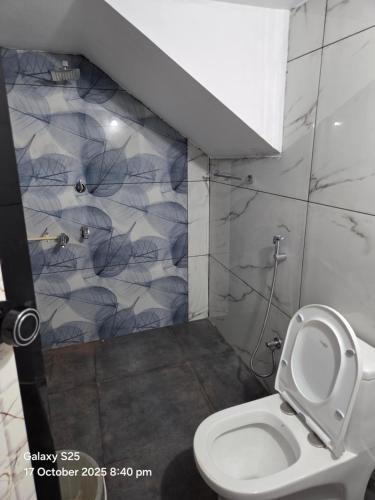 Un baño con inodoro y ducha en New Paradise Inn, en Varkala