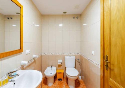 a bathroom with a toilet and a sink and a mirror at Playa Azul Amplio y luminoso con vistas al mar in Pozo Izquierdo