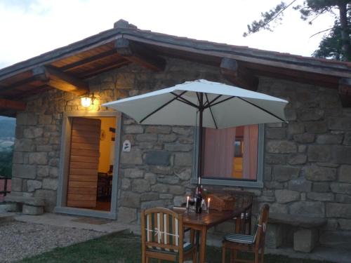 a table with an umbrella in front of a building at Magnolia in Pratovecchio