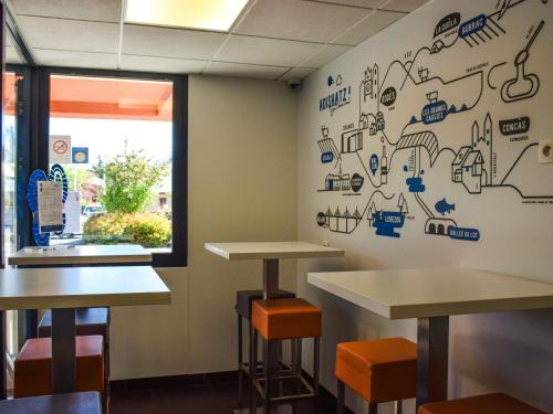 a room with two tables and a window at ibis budget Rodez in Rodez
