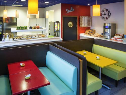 里昂里昂中央宜必思经济型酒店 - 火车东站店 的餐厅配有五颜六色的椅子和桌子