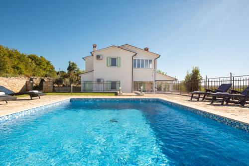 a swimming pool in front of a house at Villa Mare in Trget