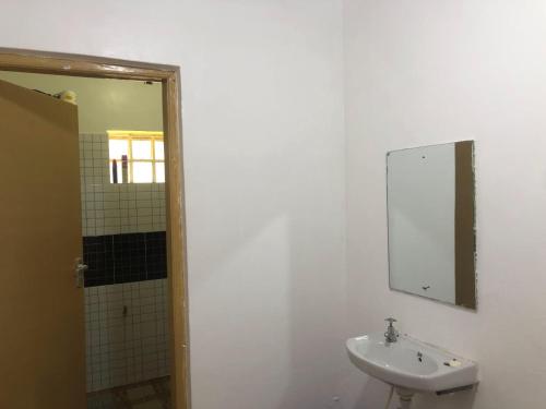 a white bathroom with a sink and a mirror at Eldoville Home in Eldoret