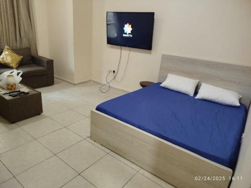 a bedroom with a bed and a tv on a wall at Super stylish in Ajman 