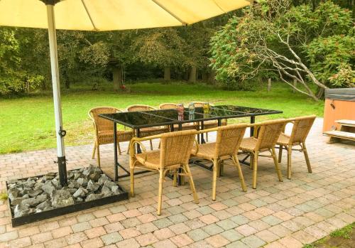 mesa de comedor y sillas bajo una sombrilla en Heidebos, en Opglabbeek
