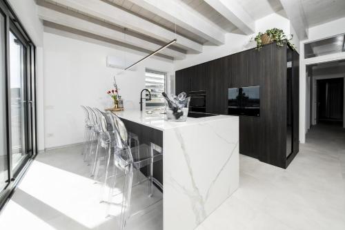 una cocina con encimera blanca y una isla negra en Attico Salia, en La Maddalena