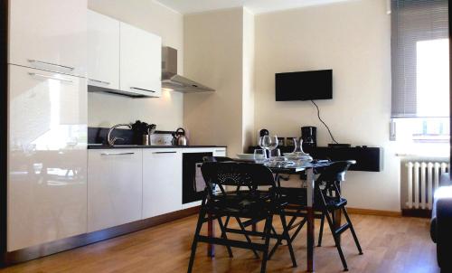 uma cozinha com mesa e cadeiras num quarto em Lilly Rose Apartment em Alba
