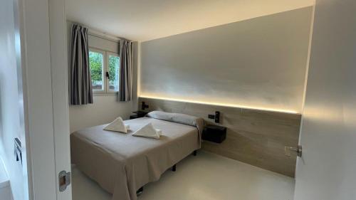 a small bedroom with a bed and a window at Aparthotel Marsol in Castelldefels