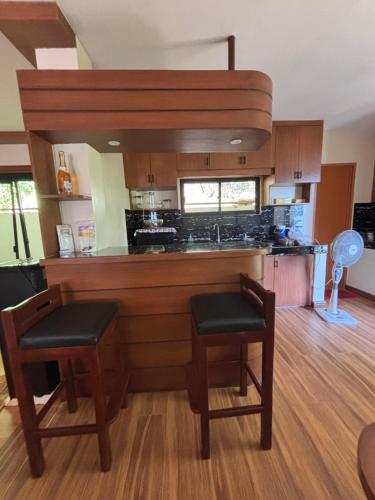 - une cuisine avec un comptoir, 2 chaises et un évier dans l'établissement Crane Island Seafront Villa, 