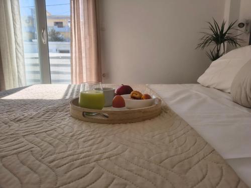 a tray of fruit and a glass of juice on a bed at Rodini Home Ylia - Rhodes in Rhodes Town