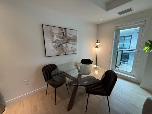 a living room with a glass table and chairs at Bright warm & spacious 1 BR in North End Halifax in Halifax