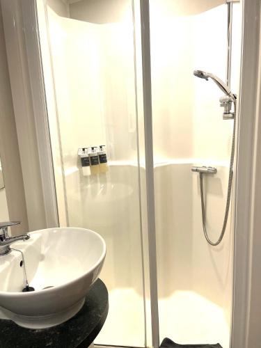 a bathroom with a white sink and a shower at Whispering Dunes - Silver Sands Holiday Park in Lossiemouth