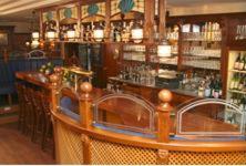 a bar with a wooden counter in a restaurant at Hof Sierksdorf in Sierksdorf