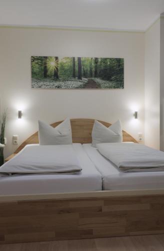 a bedroom with a bed with white sheets and pillows at Pension Sonja Müller in Nohra
