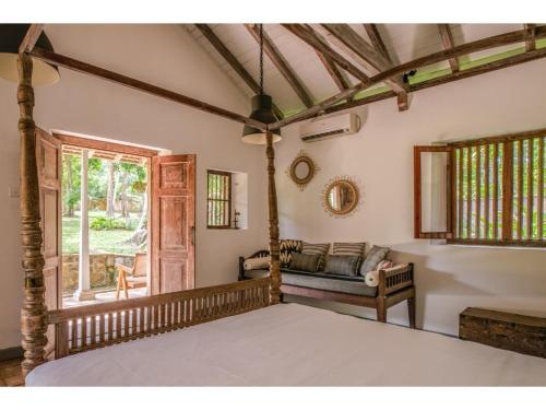 a bedroom with a bed and a couch and a window at Dutch house 5 bedrms pool chef in Habaraduwa Central