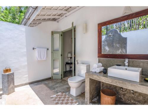 a bathroom with a toilet and a sink at Wijaya Giri walkable to beach pool chef in Ahangama