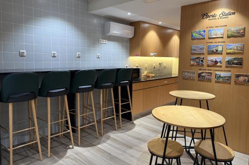 a barber shop with green stools and tables at Oporto Station Hostel & Rooms in Porto