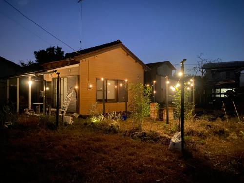 a house with lights in the yard at night at 美禄の杜 別邸 バーベキューや焚火も可能な庭付き民泊 in Mobara