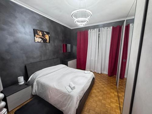 a bedroom with a white bed and red curtains at Casa di Dome in Turin