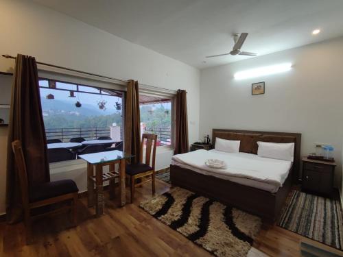 um quarto com uma cama, uma mesa e uma janela em Monal Homestay, Bhimtal em Bhīm Tāl
