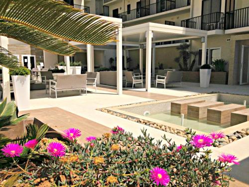 a resort with a swimming pool and flowers at Hotel Santana in St Paul's Bay