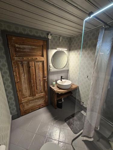 a bathroom with a sink and a wooden door at Marlens mysiga B&B in Pålänge