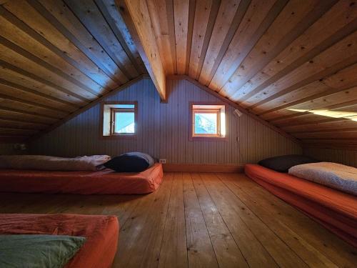 a room with three beds in a wooden house at Marlens mysiga B&B in Pålänge