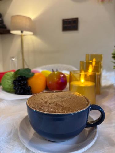 Una taza de café azul sobre una mesa con fruta. en Hotel Mini Switzerland, en Dalhousie
