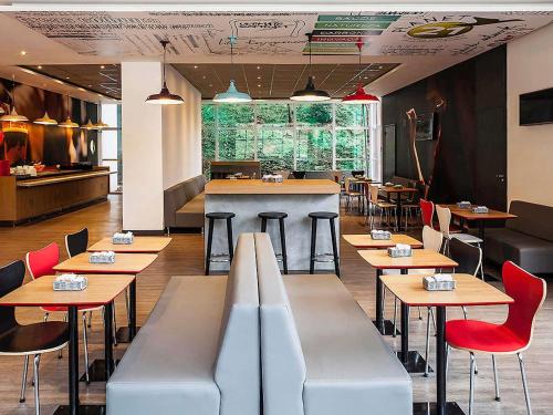 a restaurant with tables and chairs and a bar at ibis Juiz de Fora in Juiz de Fora