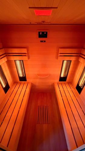 una sauna con 2 bancos de madera en una habitación en wellnesshonezovice, en Honezovice