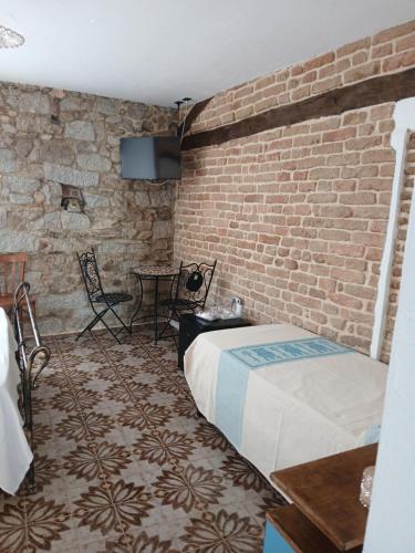 a bedroom with a bed and a brick wall at b&b s'antalena in Orgosolo