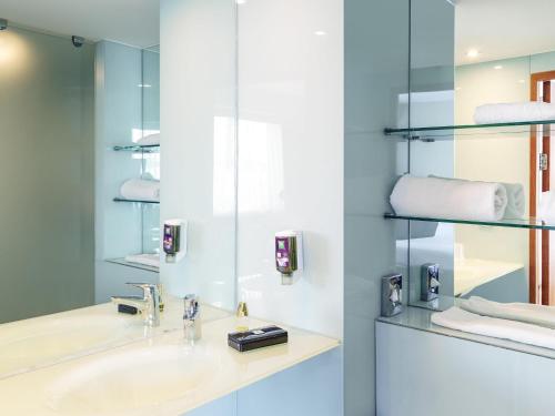 une salle de bain avec un lavabo et un miroir dans l'établissement ibis Styles Birmingham NEC & Airport, à Bickenhill