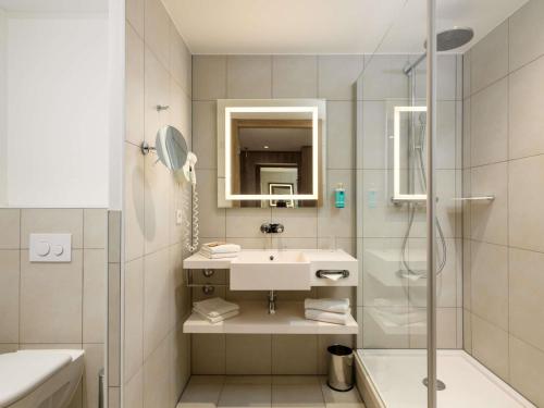 a bathroom with a sink and a shower at Novotel Nürnberg Centre Ville in Nürnberg
