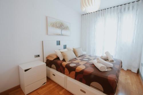 ein Schlafzimmer mit einem Bett mit Kissen darauf in der Unterkunft Family & Friends Apartment with Pool in Torrent