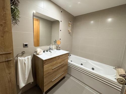 ein Badezimmer mit Badewanne und Waschbecken in der Unterkunft Family & Friends Apartment with Pool in Torrent