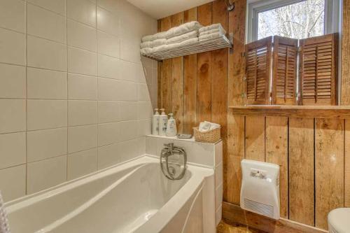 ein Badezimmer mit einer weißen Badewanne und einem Waschbecken in der Unterkunft Cozy 3 bedroom cottage 8 min from North side Tremblant in Lac-Superieur