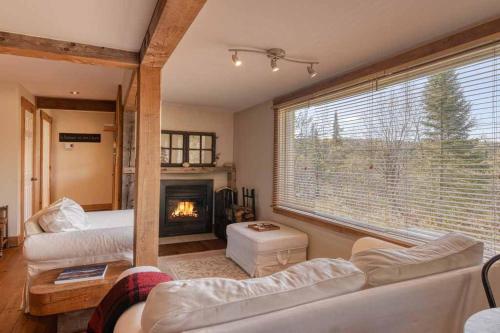 ein Wohnzimmer mit Couch und Kamin in der Unterkunft Cozy 3 bedroom cottage 8 min from North side Tremblant in Lac-Superieur