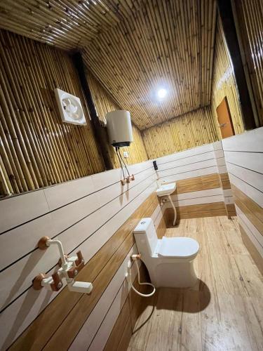 a bathroom with a toilet in a wooden ceiling at Radhika resort in Vrindāvan