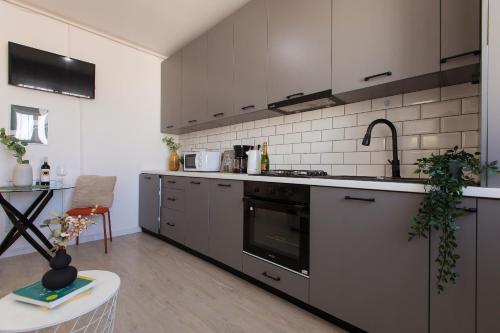 une cuisine avec un évier et une cuisinière four supérieur dans l'établissement Ivory Residence - Modern Minimalist Studio Apartment, à Bucarest