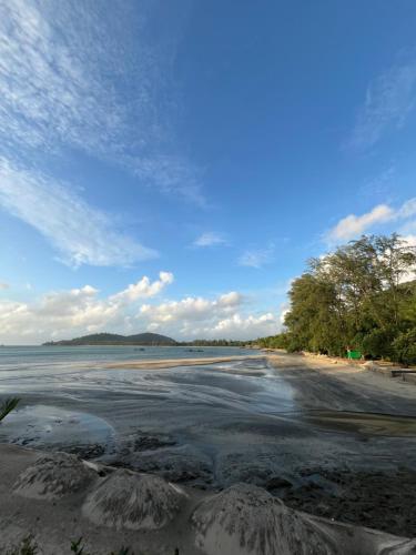 a beach with water and trees and a blue sky at Ta Dang Bay - Bungalow in Koh Chang Ranong